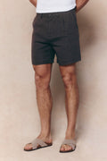Brown Javier pleated waistband linen shorts on a model, featuring belt loops and side pockets.
