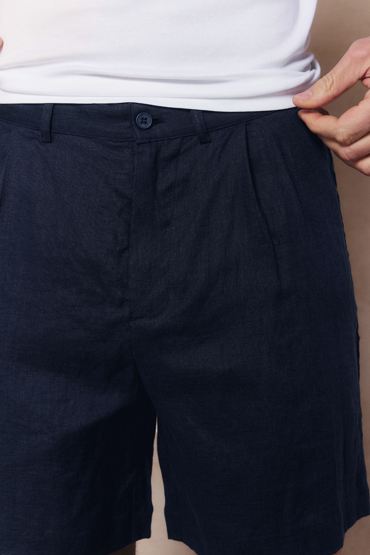 Navy Javier pleated waistband linen shorts with button closure and belt loops.
