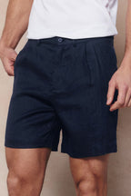 Men's navy linen shorts with pleated waistband, button closure, belt loops, and side pockets.