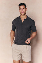 Man wearing a regular fit Juan Button Thru Boucle Knit Striped Polo in Mushroom with full button-through front.