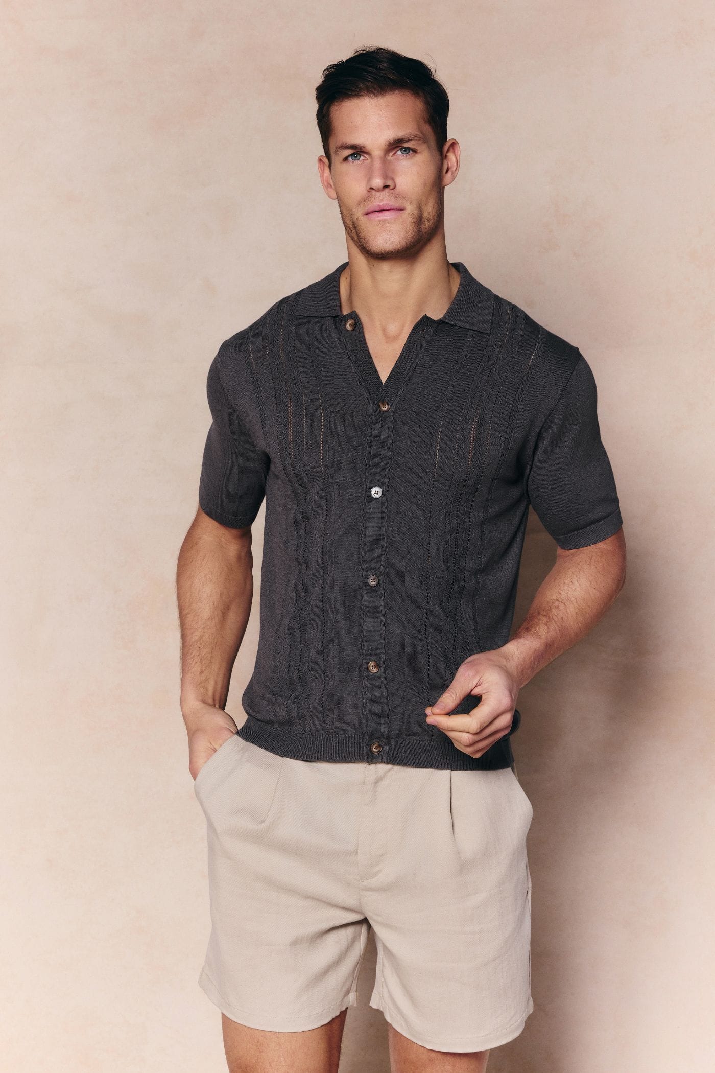 Man wearing a regular fit Juan Button Thru Boucle Knit Striped Polo in Mushroom with full button-through front.