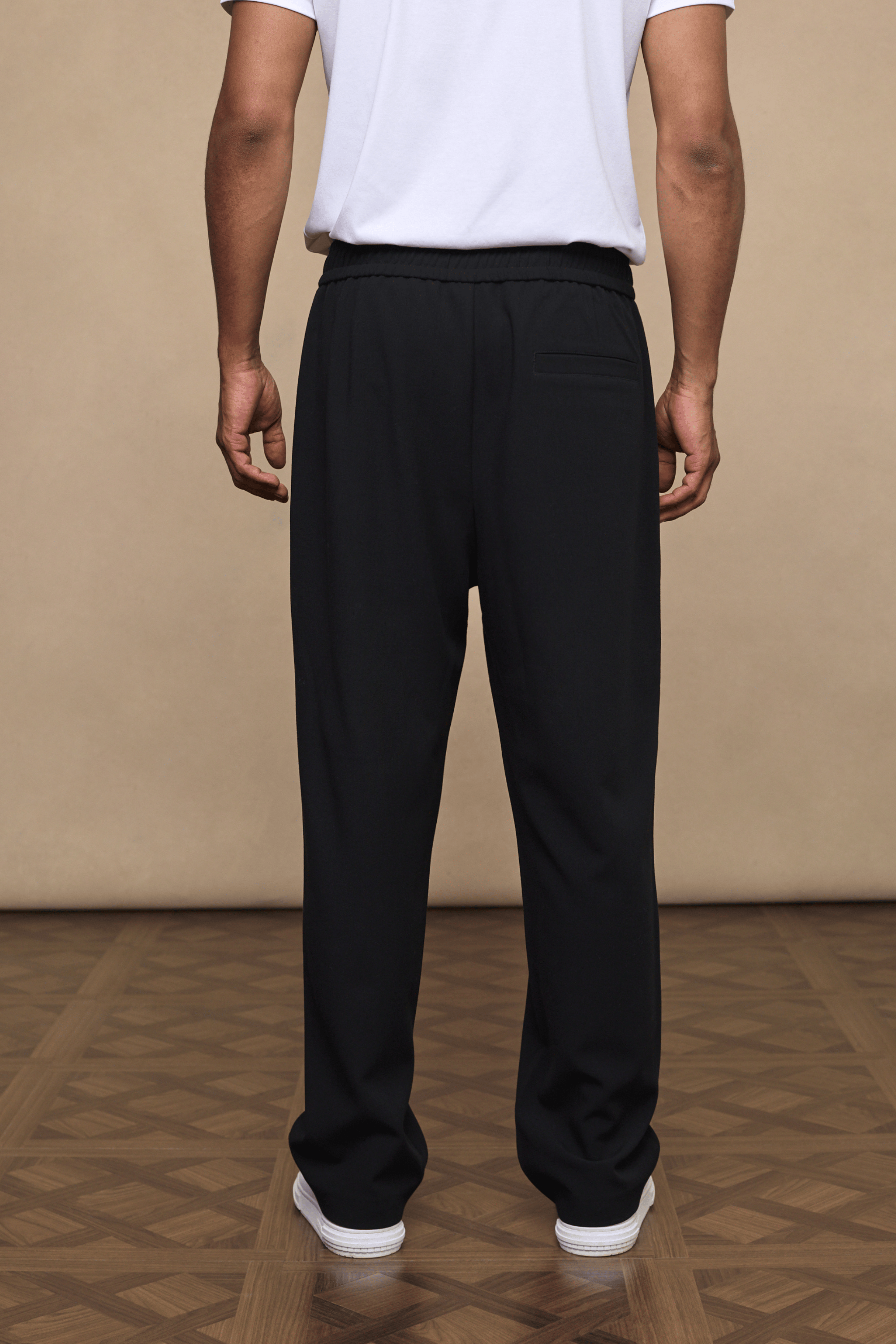 Black Julien relaxed panelled trousers with a straight fit, subtle top-stitched detailing, and elasticated waist.