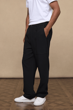 Man wearing black Julien Relaxed Panelled Trousers with a white t-shirt and white sneakers.