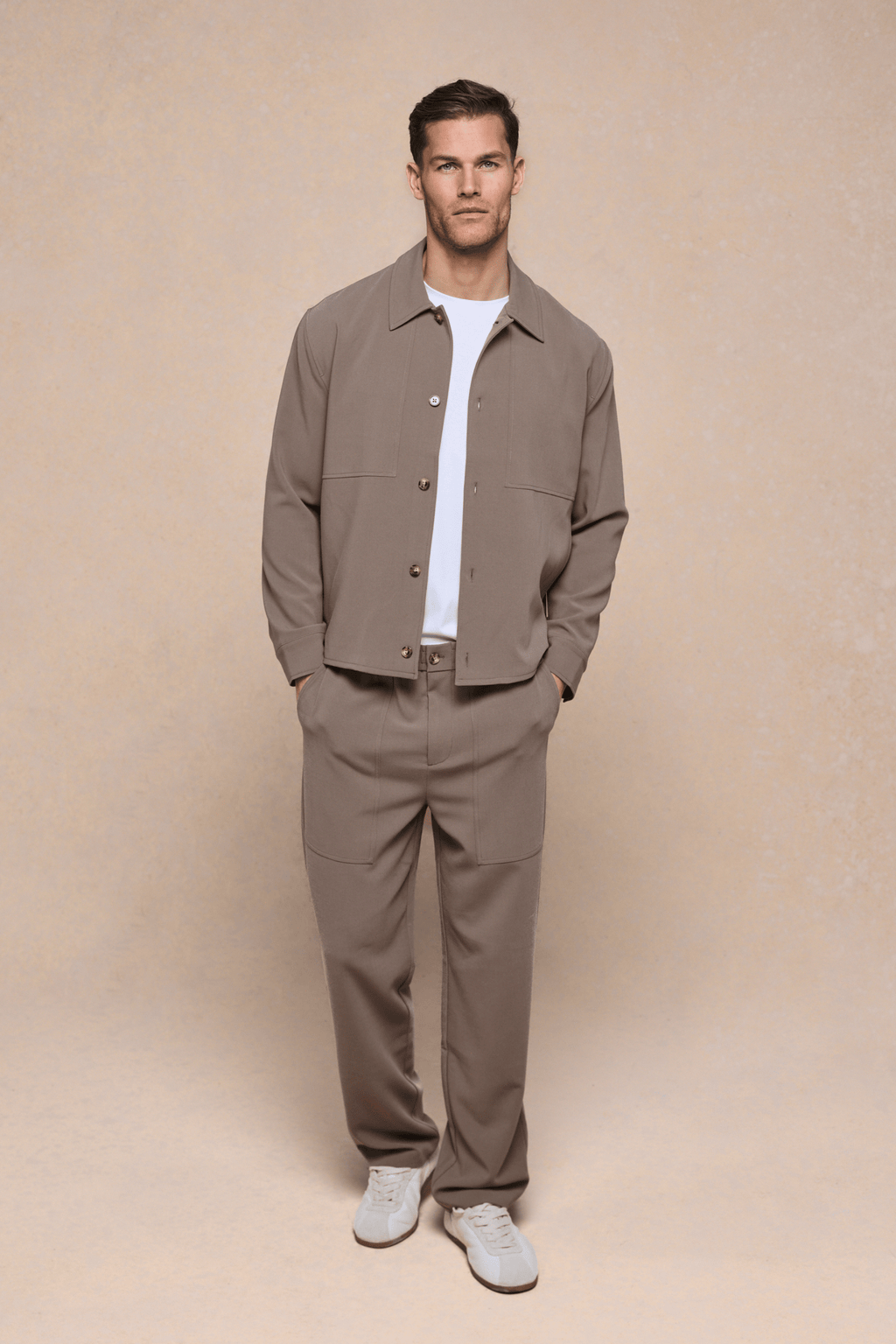 Man wearing olive Julien Relaxed Panelled Trousers and matching jacket with a white t-shirt.