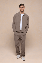 Man wearing olive Julien Relaxed Panelled Trousers and matching jacket with a white t-shirt.