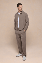 Man in olive Julien Relaxed Panelled Trouser and matching jacket, white t-shirt, and sneakers.