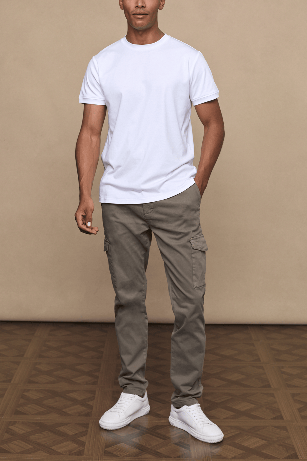 Man wearing dark olive Lenox Cargo pants with utility pockets, a white t-shirt, and white sneakers.