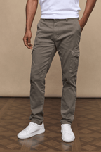 Men's dark olive Lenox Cargo pants with straight leg fit, utility pockets, and white sneakers.