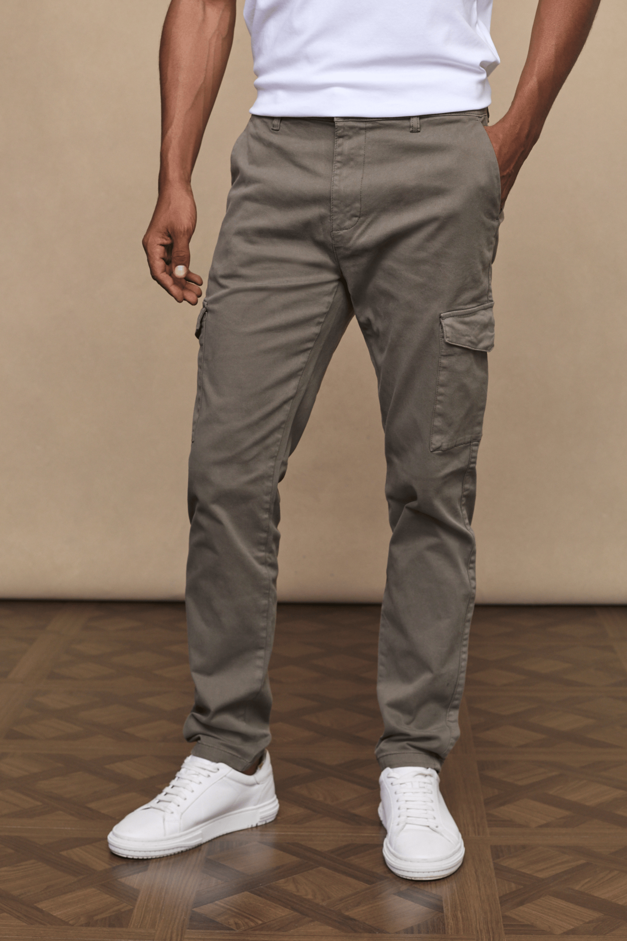 Men's dark olive Lenox Cargo pants with straight leg fit, utility pockets, and white sneakers.