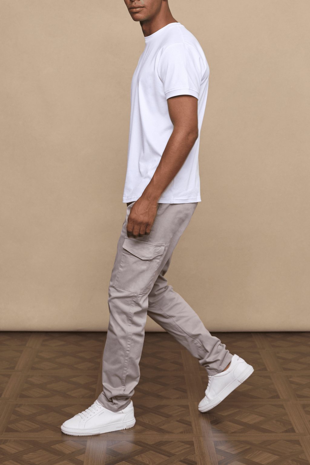 Man in Lenox Cargo Greige pants with utility pockets, straight leg, and white t-shirt.