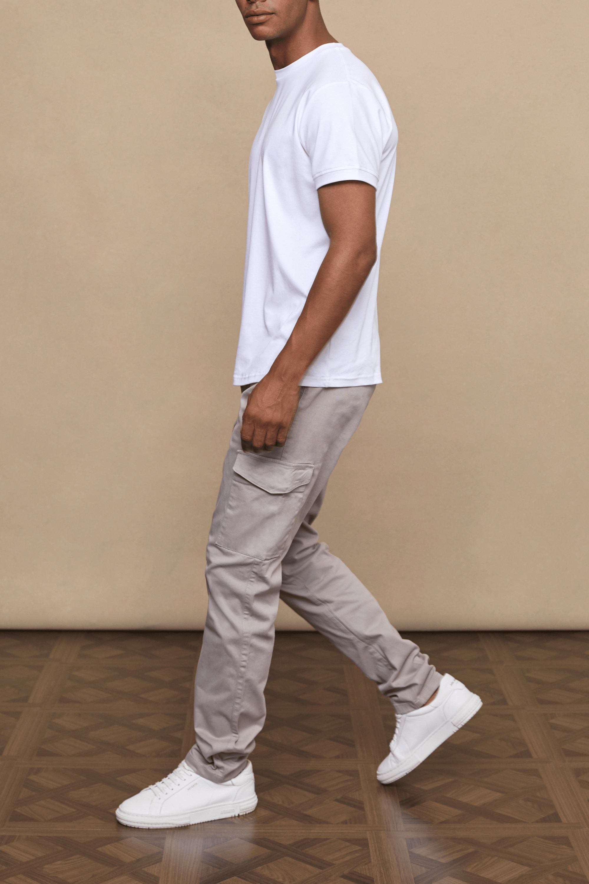 Man in Lenox Cargo Greige pants with utility pockets, straight leg, and white t-shirt.