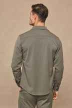 Man from behind wearing a dark olive Leo Overshirt with a structured look and refined drape.
