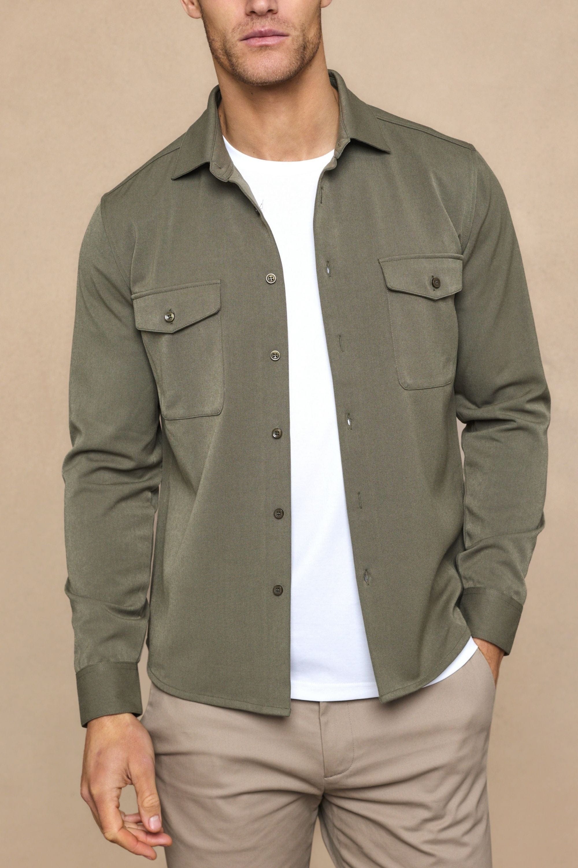 Men's dark olive Leo overshirt with dual chest pockets, worn open over a white tee.