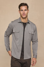 Leo Overshirt in warm grey, soft stretchy fabric, dual chest pockets, tonal buttons, worn over a dark tee.