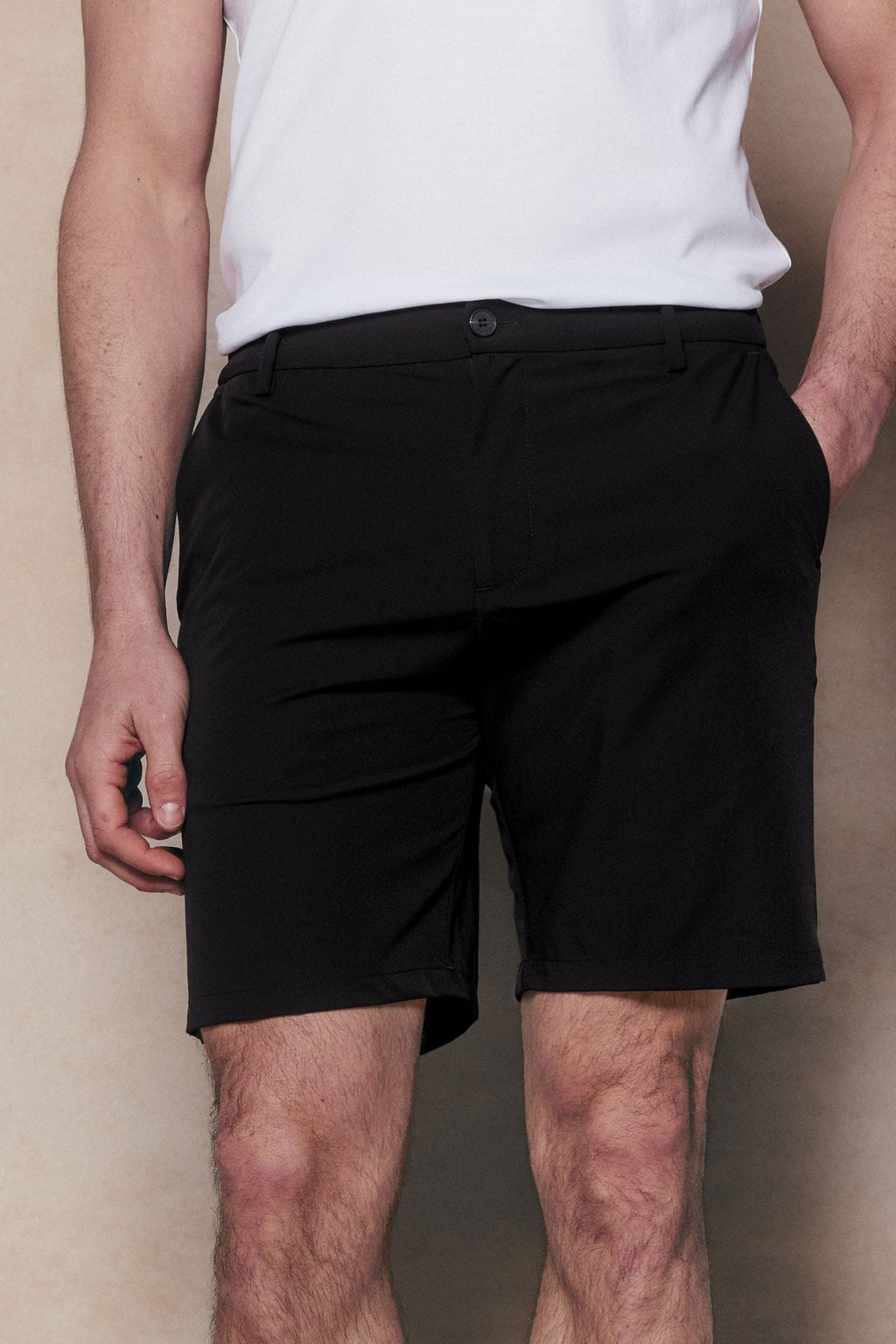 Man wearing black Luiz Hybrid Shorts with a tailored chino look and concealed zip pockets.