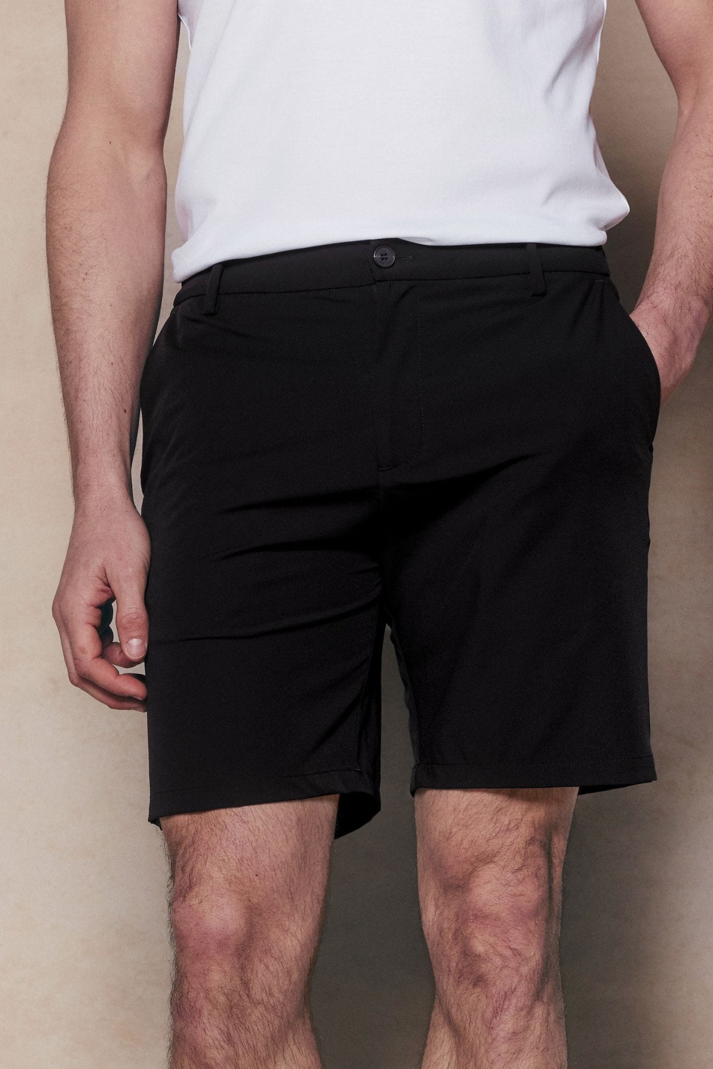 Man wearing black Luiz Hybrid Shorts with a tailored chino look and concealed zip pockets.