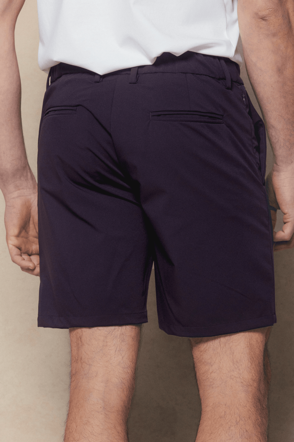 Man from behind wearing navy Luiz Hybrid Shorts with a tailored finish and back pockets.