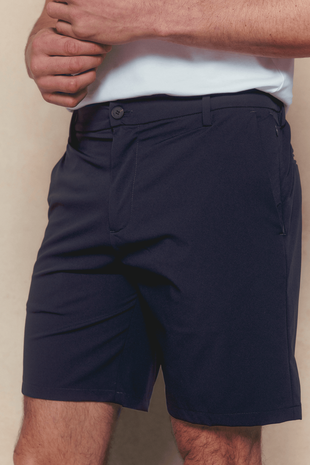 Man wearing navy Luiz Hybrid Shorts with a white shirt, showcasing the tailored fit and stretch fabric.