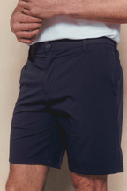 Man wearing navy Luiz Hybrid Shorts with a white shirt, showcasing the tailored fit and stretch fabric.