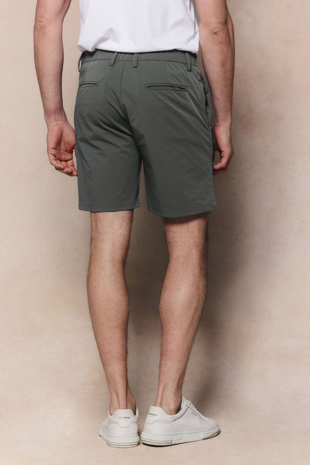 Man wearing sage Luiz Hybrid Shorts with a tailored finish, belt loops, and back pockets.