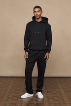 Man wearing a black Luxe Straight Leg Jogger and matching hoodie, showcasing the fabric and fit.