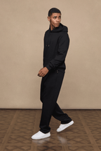 Man wearing black Luxe Straight Leg Joggers and matching hoodie, showcasing the straight-leg fit and subtle sheen.