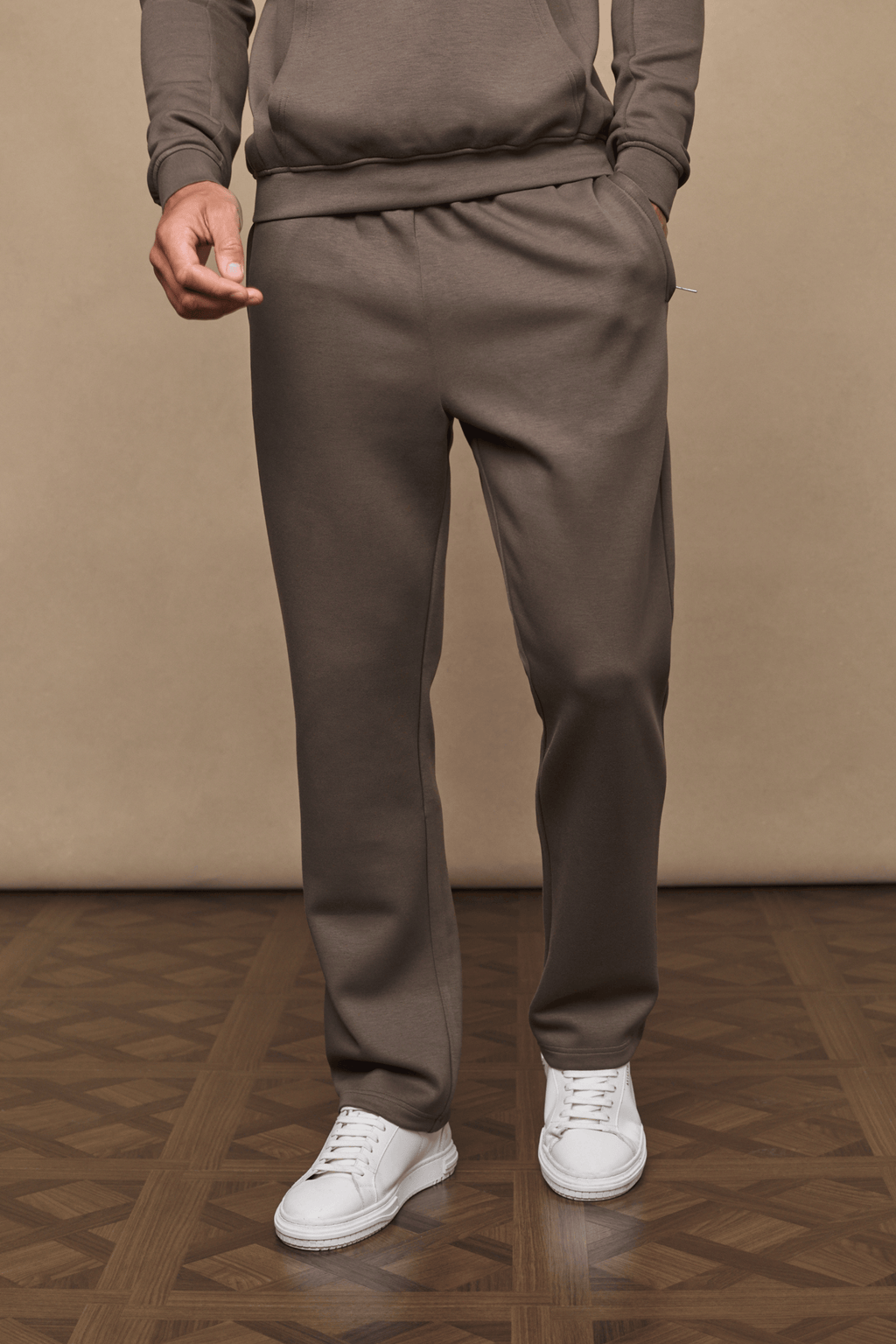 Men's Luxe Straight Leg Jogger in Burnt Olive, made from soft Luxe Fabric, with side pockets and white sneakers.