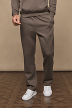 Men's Luxe Straight Leg Jogger in Burnt Olive, made from soft Luxe Fabric, with side pockets and white sneakers.