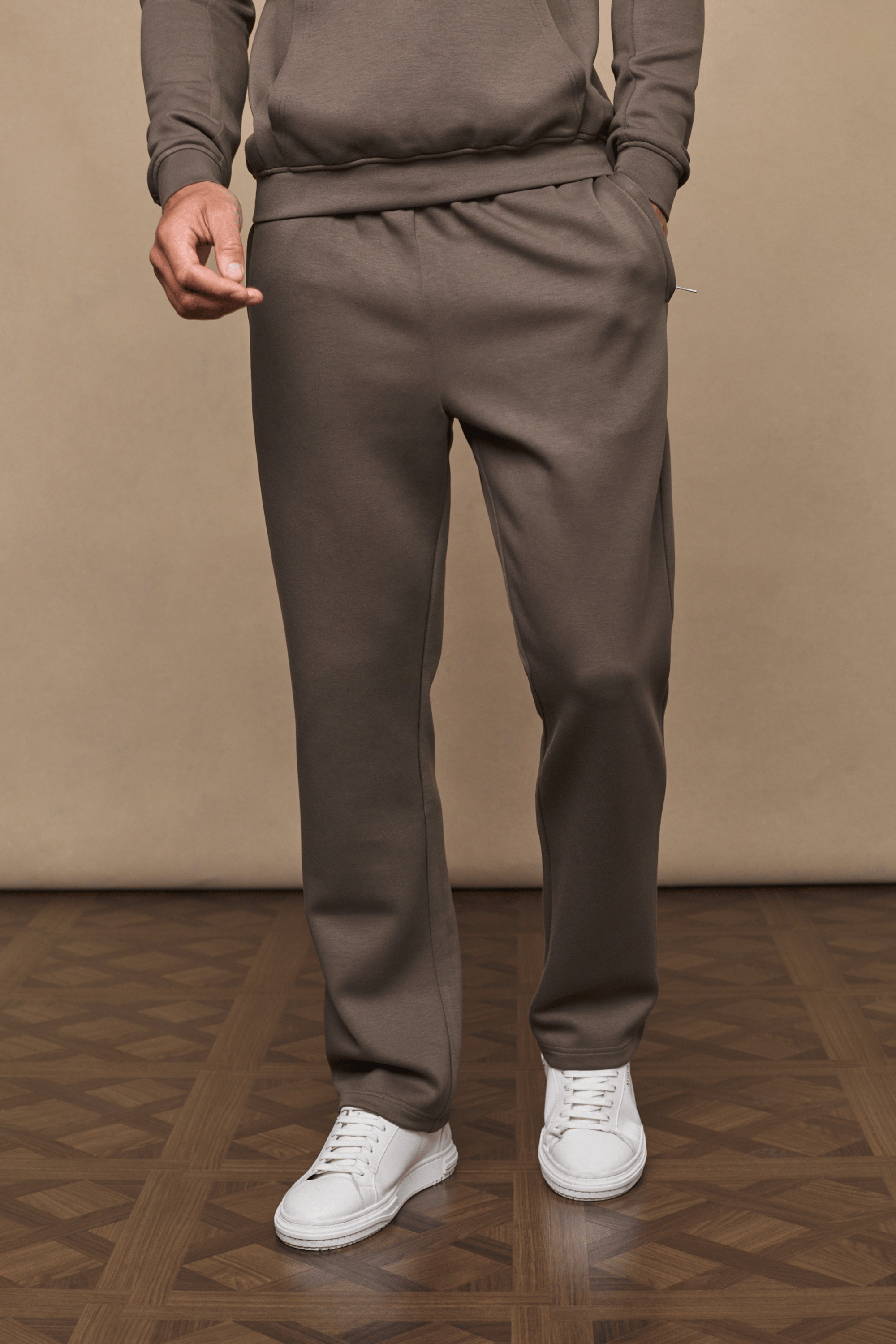 Men's Luxe Straight Leg Jogger in Burnt Olive, made from soft Luxe Fabric, with side pockets and white sneakers.