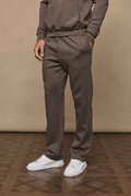 Man wearing Luxe Straight Leg Jogger in Burnt Olive, made from soft Luxe Fabric, with side pockets and white sneakers.
