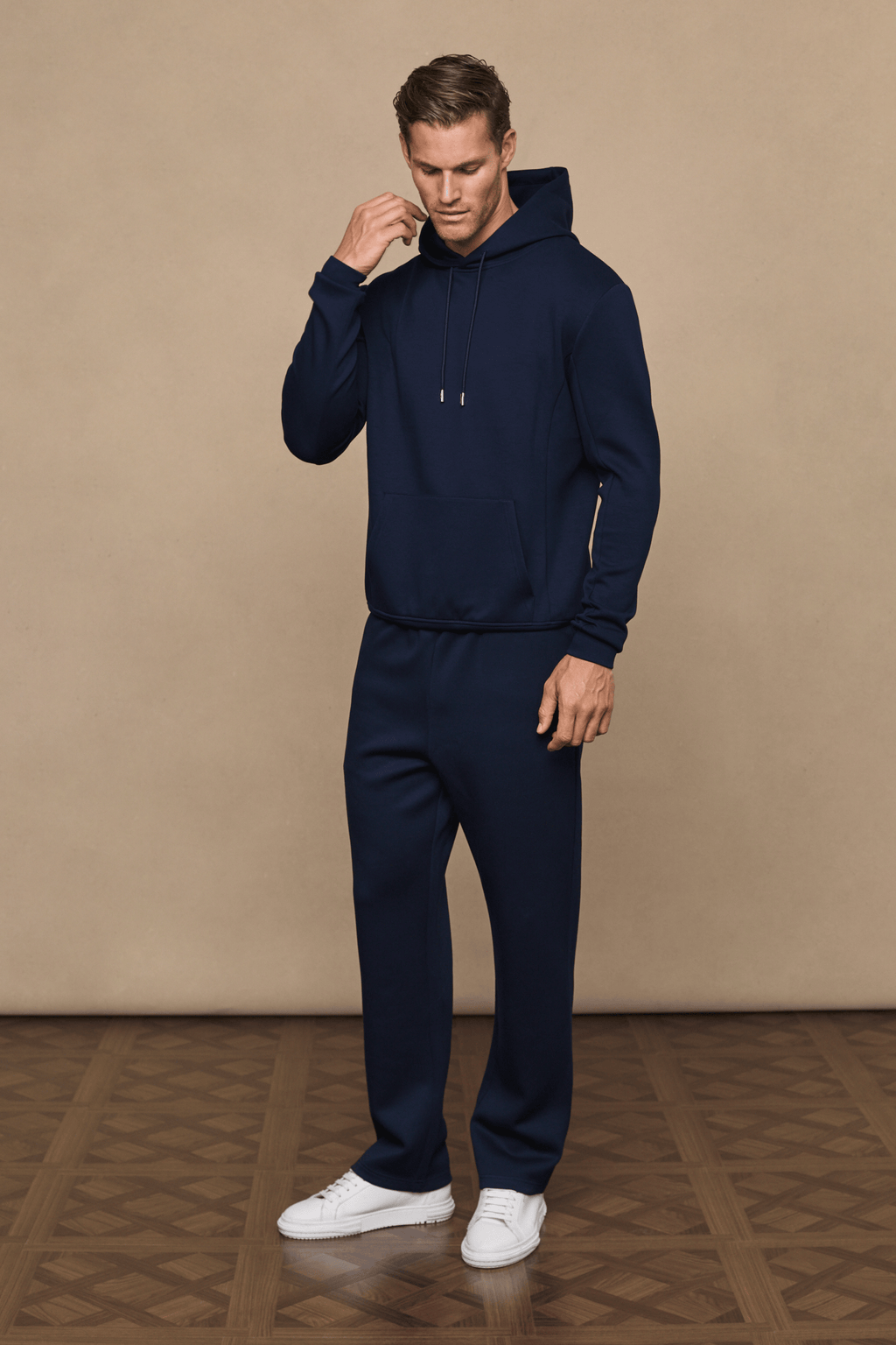 Man wearing a navy Luxe Straight Leg Jogger and matching hoodie, featuring a subtle sheen and clean silhouette.