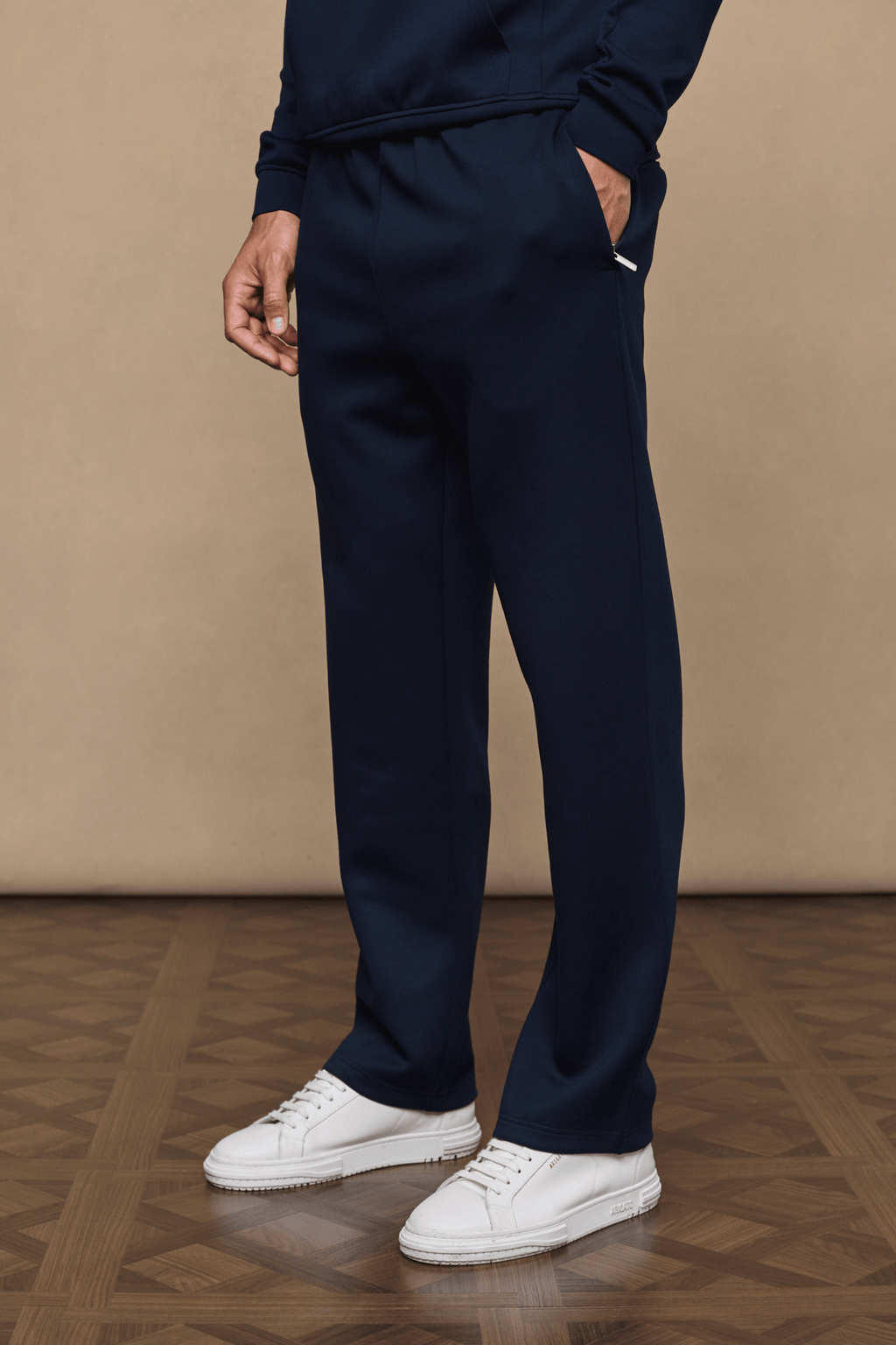 Navy Luxe Straight Leg Jogger with side pockets, subtle sheen, and white sneakers.