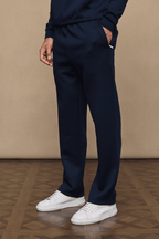 Navy Luxe Straight Leg Jogger with side pockets, subtle sheen, and white sneakers.