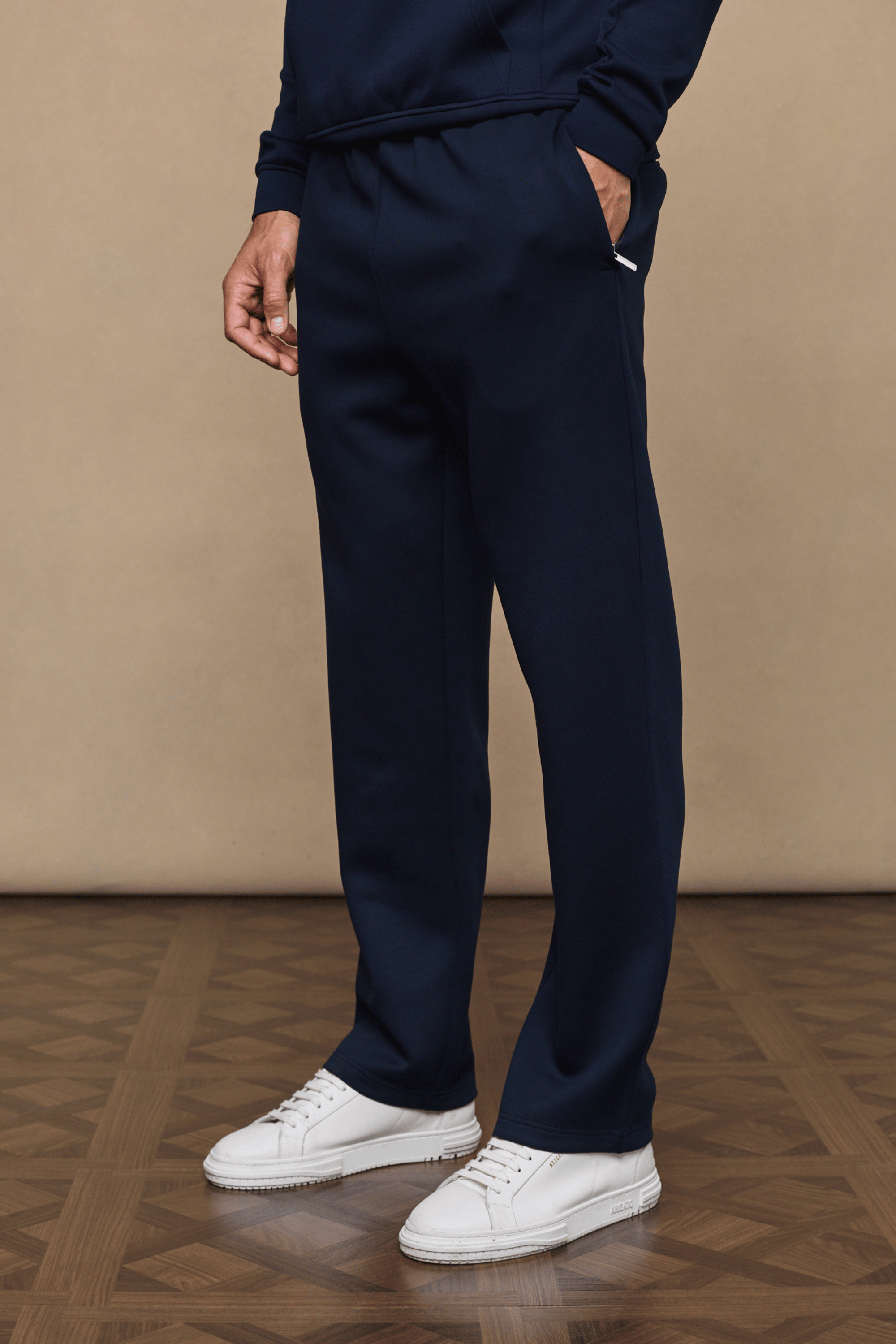 Navy Luxe Straight Leg Jogger with side pockets, subtle sheen, and white sneakers.