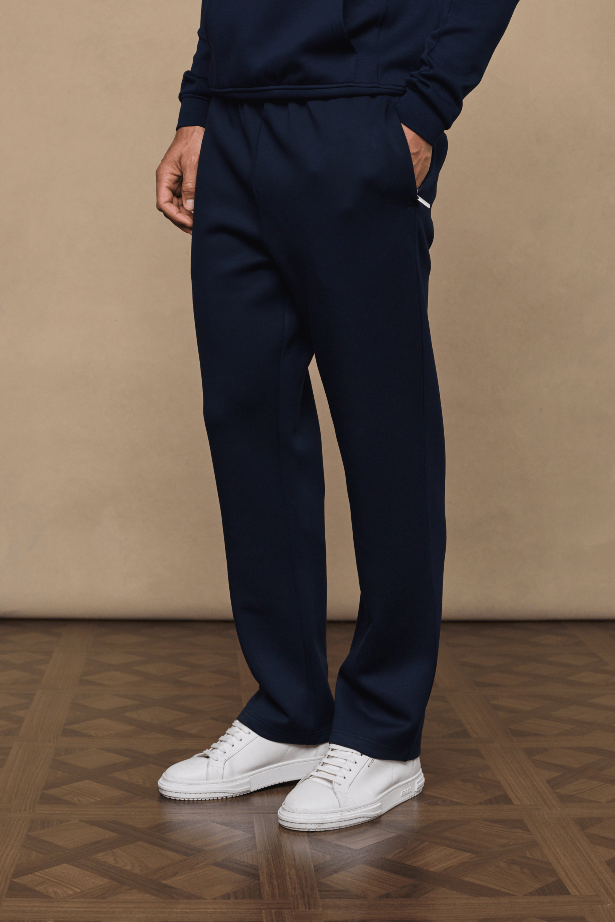 Navy Luxe Straight Leg Jogger, soft fabric, side pockets, paired with white sneakers.