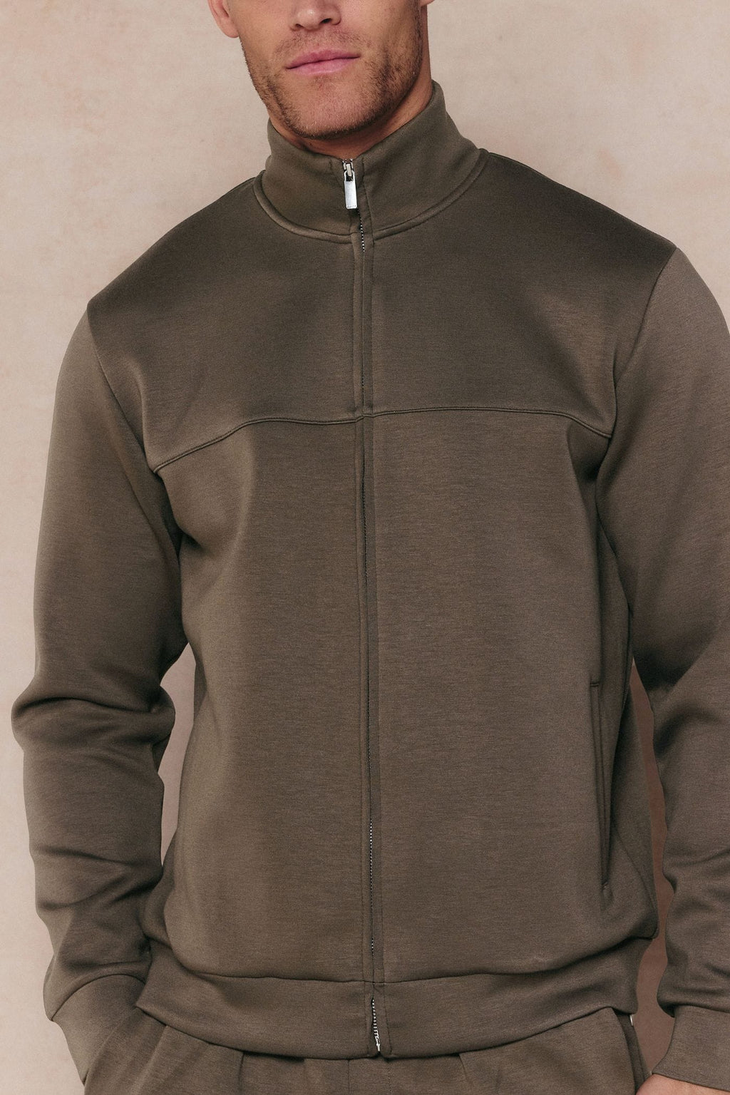 Men's Luxe Zip Through Jacket in Burnt Olive, featuring a high collar, metal zipper, and paneled design.