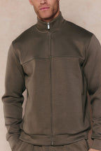 Men's Luxe Zip Through Jacket in Burnt Olive, featuring a high collar, metal zipper, and paneled design.