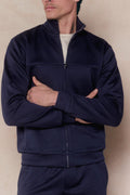 Man in a navy Luxe Zip Through Jacket with a stand collar and silver zipper, arms crossed.