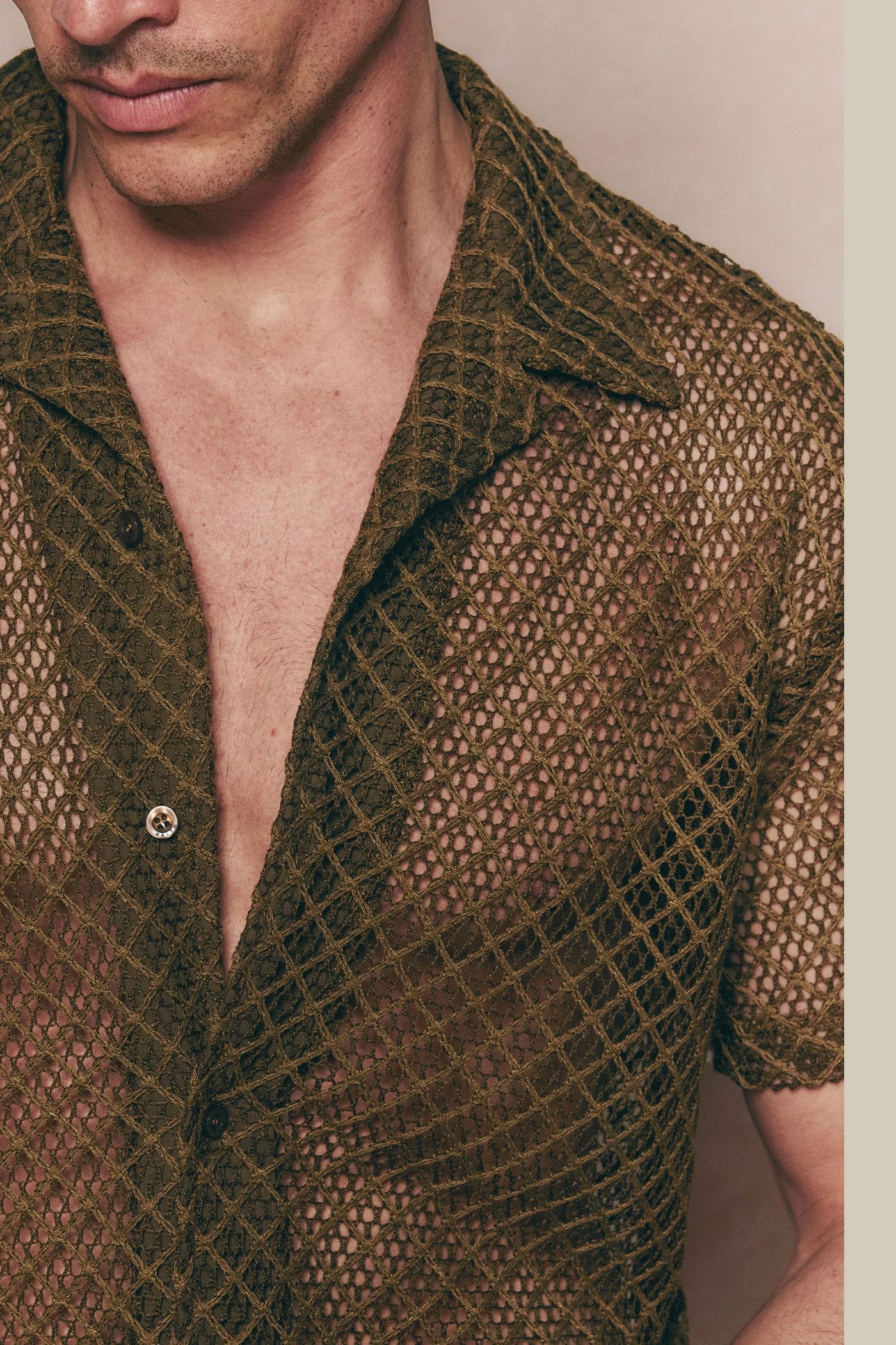 Close-up of a man wearing a brown Marcelo Short Sleeve Lace Shirt made from open, textured cotton fabric.