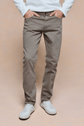 Marco Jean in Burnt Olive, straight-slim fit, 98% cotton denim, with white sneakers.