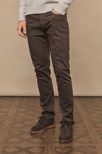 Man wearing dark brown Marco Jean, a straight-slim fit denim with a leather back patch, paired with brown suede shoes.