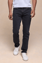 Man wearing Marco Washed Jean in light washed black denim with a straight-slim fit and white sneakers.