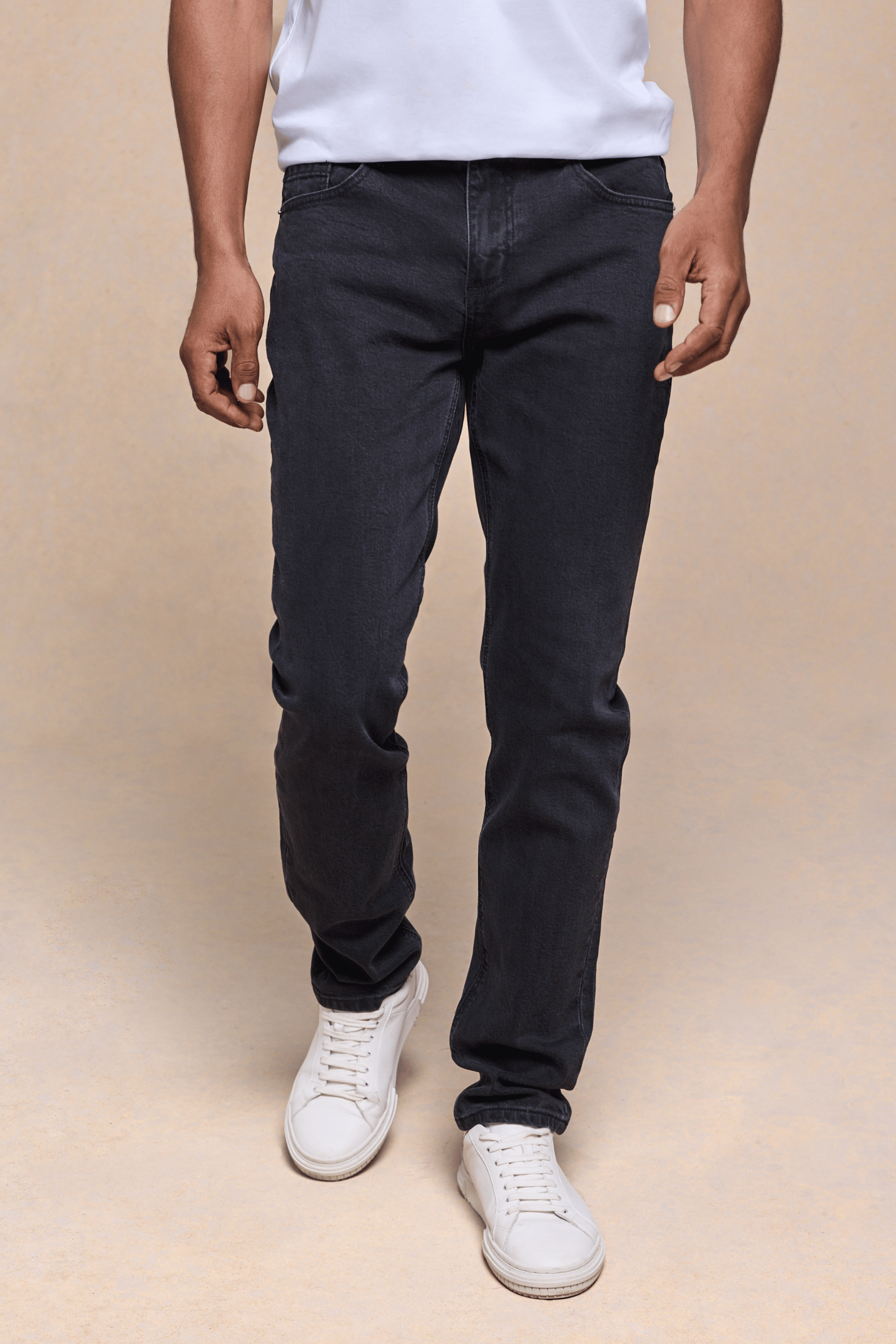 Man wearing Marco Washed Jean in light washed black denim with a straight-slim fit and white sneakers.