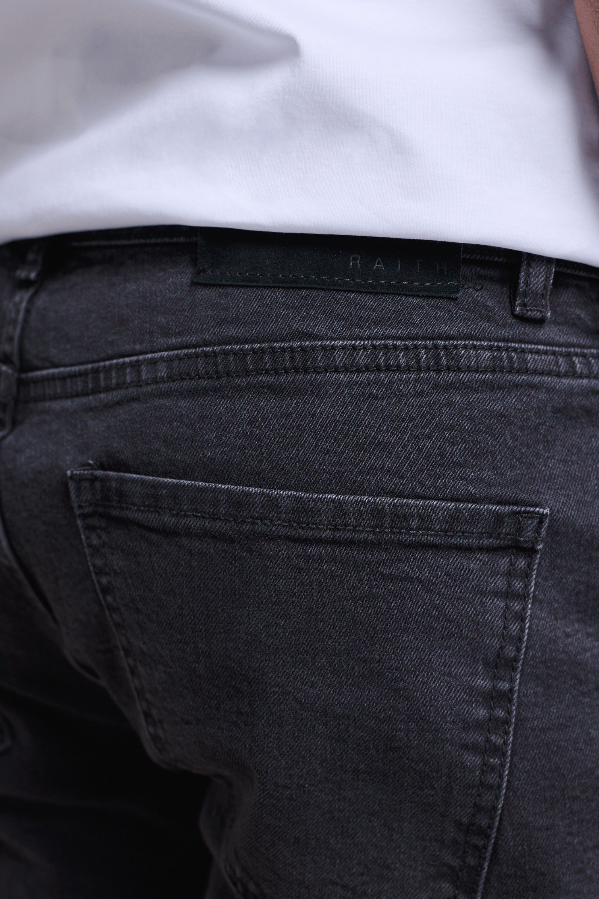Marco Washed Jean in light washed black, showing back pockets and a dyed-to-match leather patch.