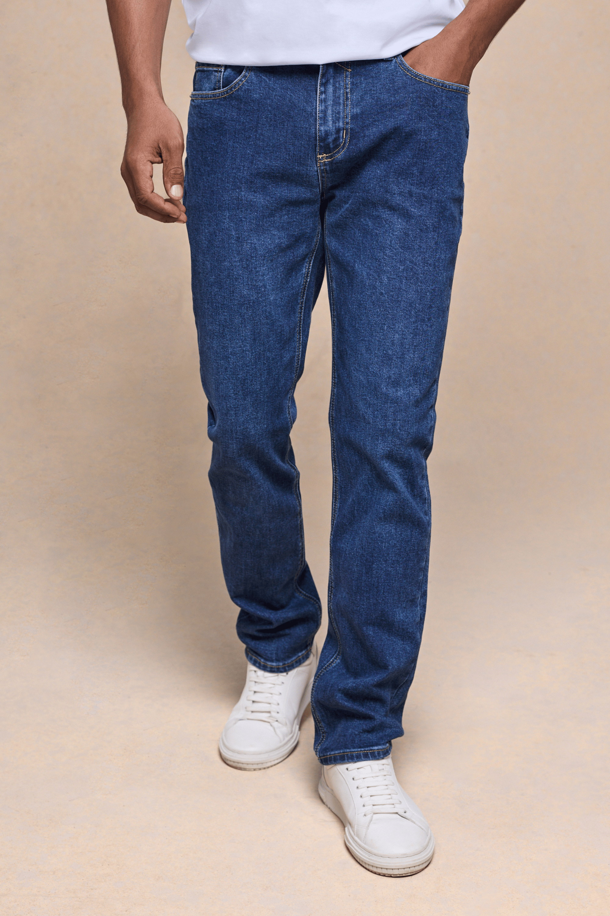 Men's Marco Washed Jean in mid-wash indigo denim, straight-slim fit, with white sneakers.
