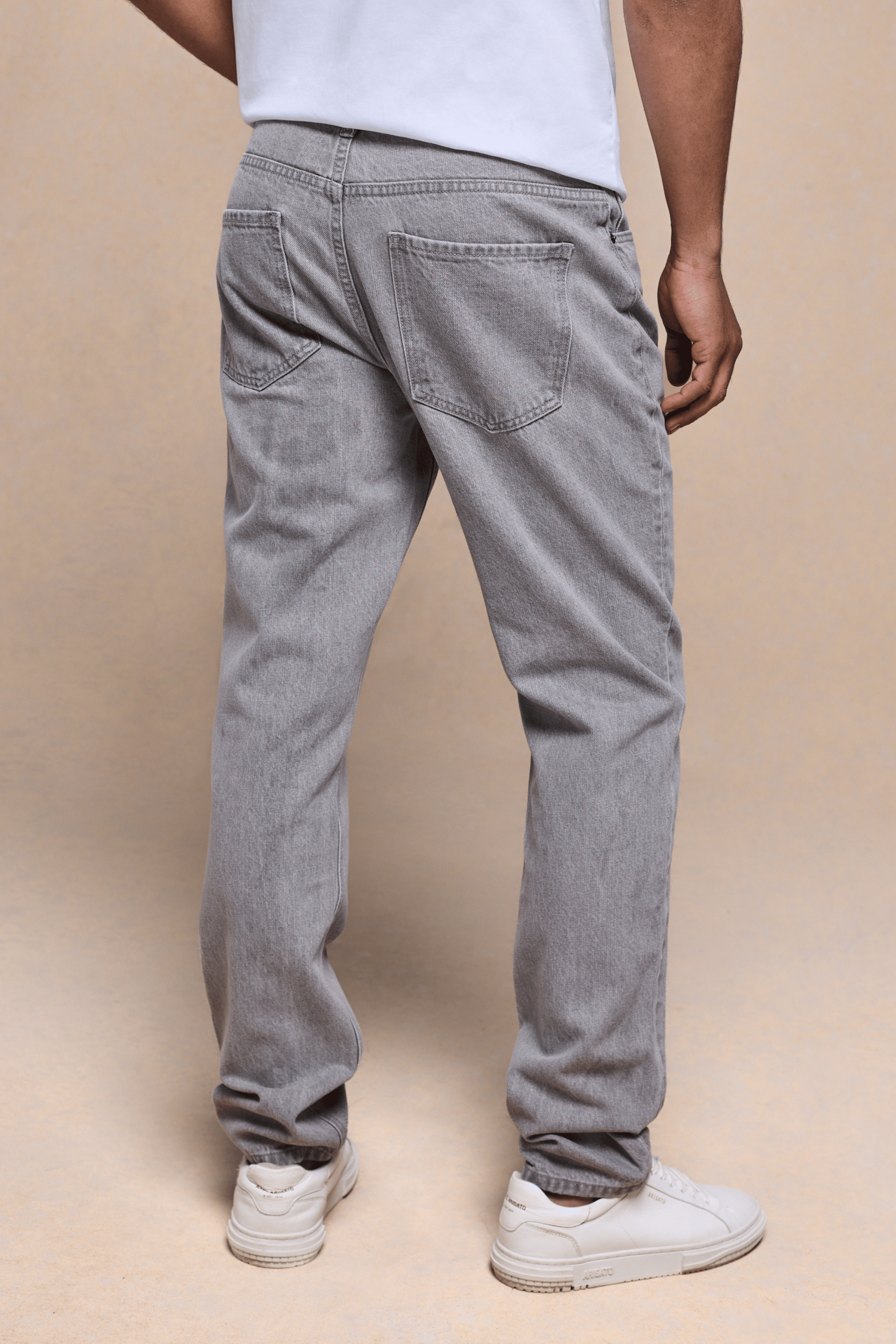 Man wearing Marco Washed Jean in Stone Grey, showing the straight-slim fit, back pockets, and leather patch.