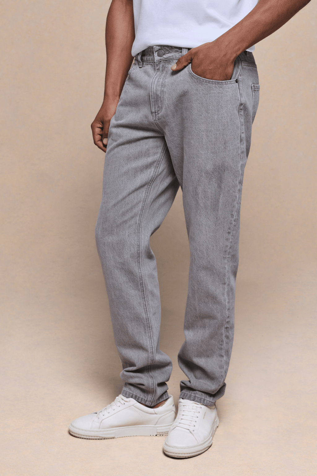 Men's Marco Washed Jean in Stone Grey, straight-slim fit, 98% cotton denim, with pockets and white sneakers.