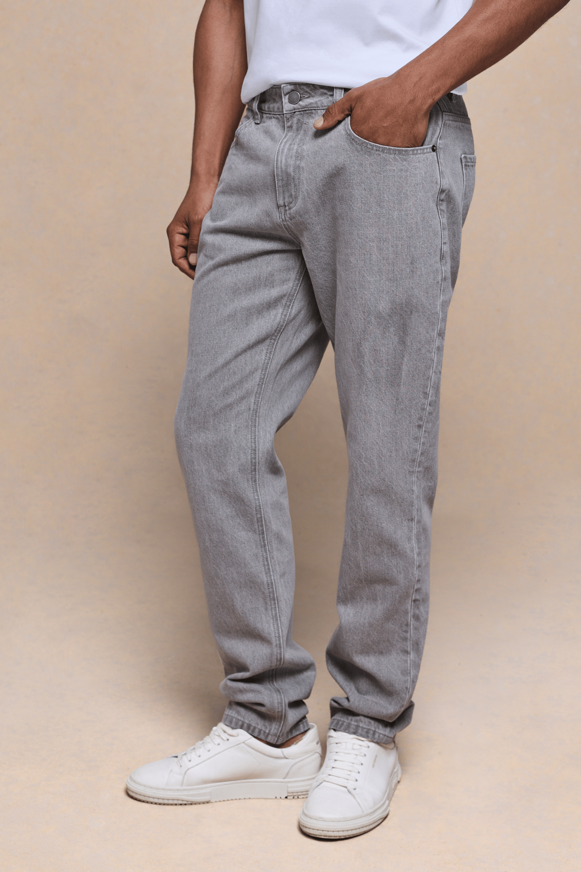 Men's Marco Washed Jean in Stone Grey, straight-slim fit, 98% cotton denim, with pockets and white sneakers.