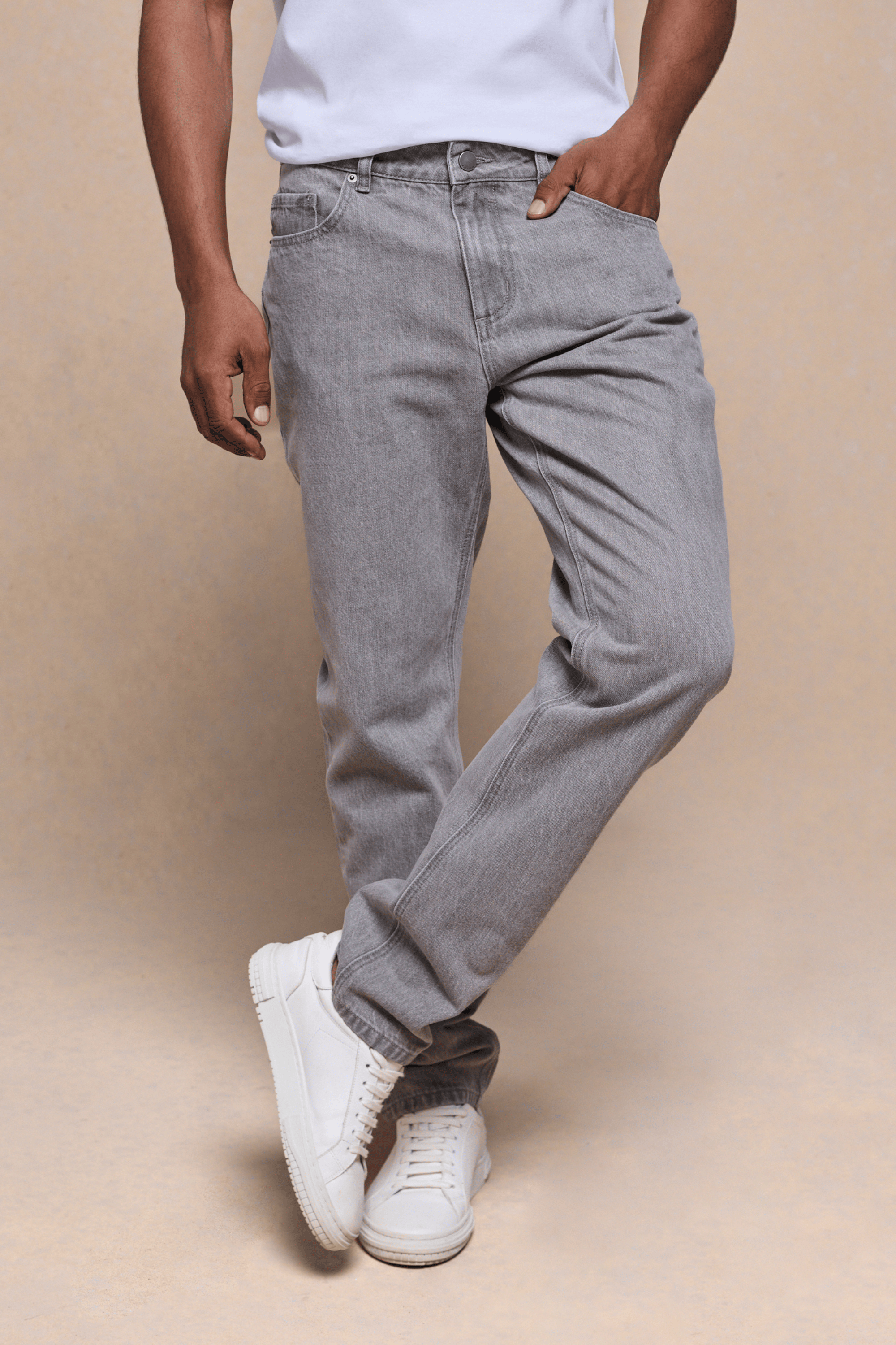 Man wearing Marco Washed Jean in Stone Grey, a straight-slim fit cotton-elastane denim with white sneakers.