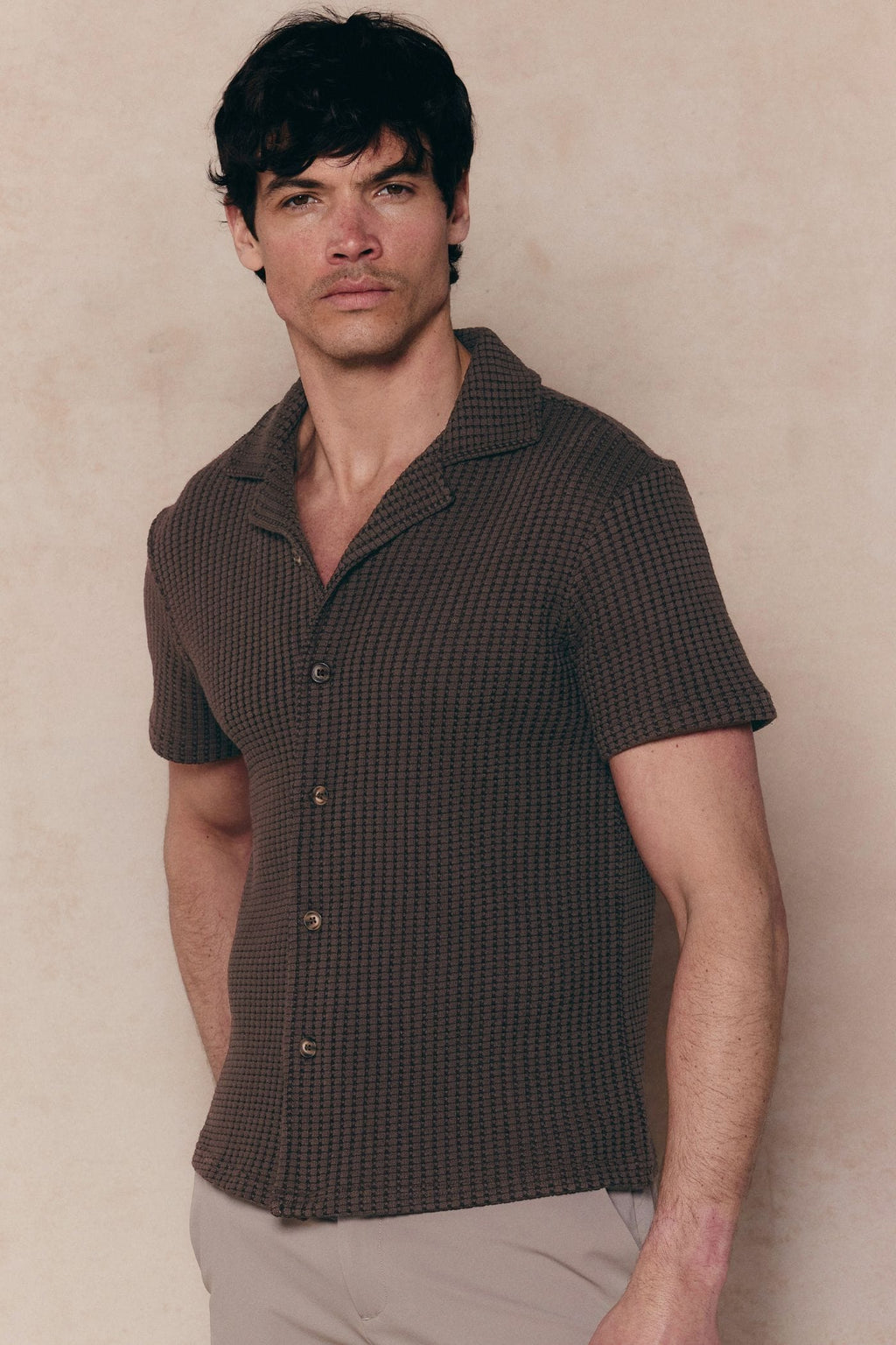 Man wearing a brown Marcos patterned waffle short sleeve shirt with an open collar and button-through front.